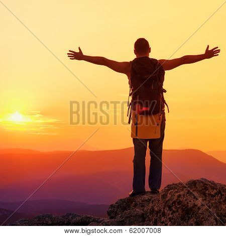Guy In The Mountains At Sunset. The Concept Of Freedom