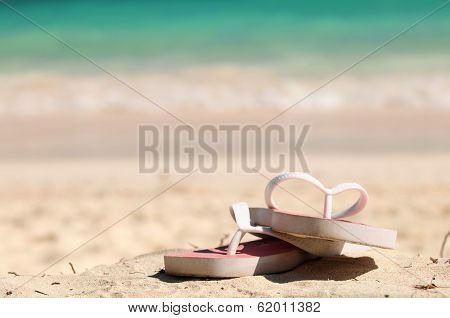Flipflops on a sandy ocean beach - vacation concept