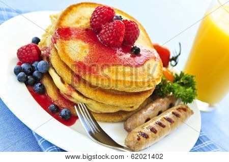 Breakfast of buttermilk pancakes with sausages and fresh berries