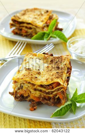 Two servings of fresh baked lasagna on plates