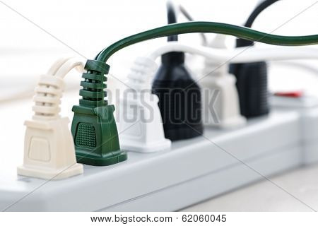 Many plugs plugged into electric power bar
