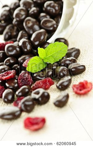 Chocolate covered cranberries spilling from glass dish