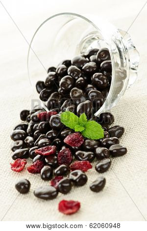 Chocolate covered cranberries spilling from glass dish
