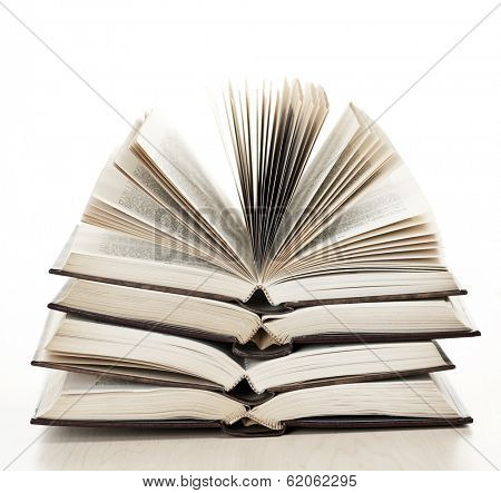 Stack of open old fanned hardcover leather bound books