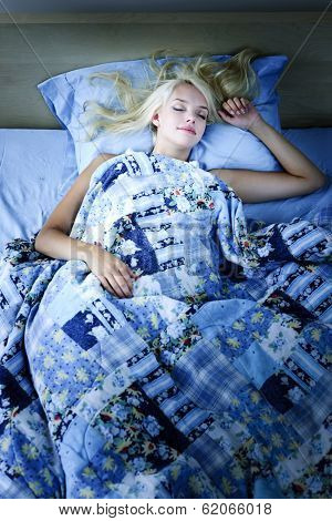 Young woman sleeping peacefully at night in bed
