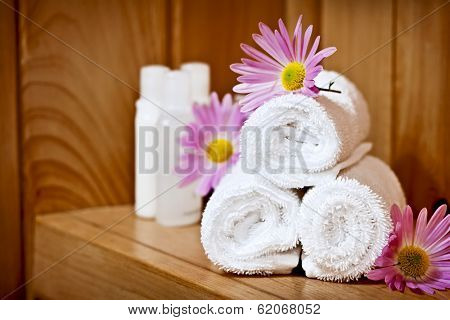 White rolled up spa towels with body care products