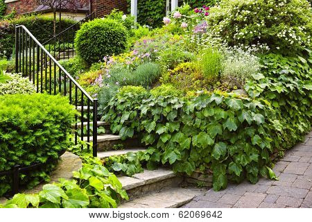 Landscaped garden path with natural stone steps and metal railing