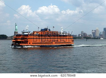 NEW YORK - JULY 11: The Staten Island ferry passes the Statue of Liberty  in New York City on Sunday, July 11, 2010