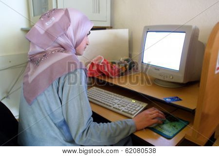 NOVI PAZAR, SERBIA - APRIL 29: A traditionally dressed Muslim woman surfs the internet at an internet cafe in the southern Serbian city of Novi Pazar on April 29, 2002 in Novi Pazar, Serbia.