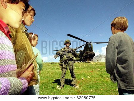 KUKES, ALBANIA, 19 APRIL 1999 - Kosovar Albanian children await relief supplies from a Dutch army helicopter at a refugee camp in northern Albania.