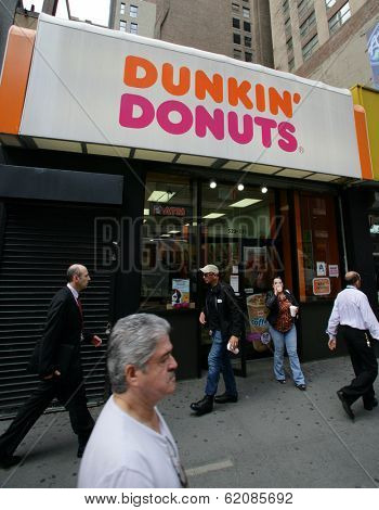 NEW YORK CITY - APRIL 19: Pedestrians walk past a Dunkin' Donuts franchise in New York City, on Friday, April 19, 2013.
