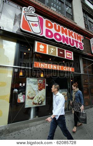 NEW YORK CITY - APRIL 19: Pedestrians walk past a Dunkin' Donuts franchise in New York City, on Friday, April 19, 2013.
