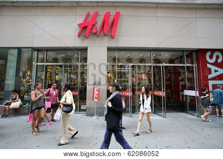 NEW YORK CITY - JULY 8: Shoppers walk past a H&M retail clothing store in New York City, New York, on Monday, July 8, 2013. H & M Hennes & Mauritz AB is a Swedish company.