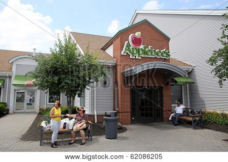 WOODBURY COMMON - JULY 9: Pedestrians walk past an Applebee's restaurant in Woodbury Common, New York, on Tuesday, July 9, 2013. 