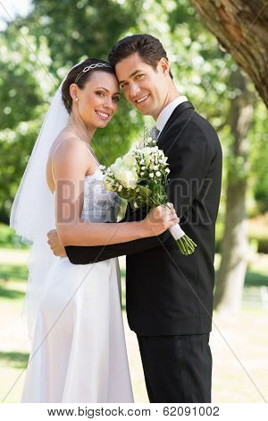 Portrait of happy newly wed couple with head to head standing in garden