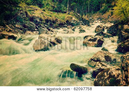 Vintage retro hipster style travel image of cascade of Kuhfluchtwasserfall. Long exposure for motion blur. Farchant, Garmisch-Partenkirchen, Bavaria, Germany
