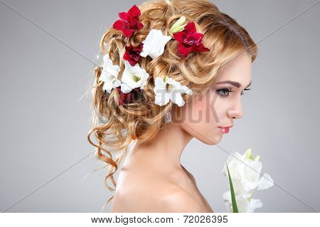 Beautiful girl, isolated on a light - grey background with varicoloured flowers in hairs, emotions, cosmetics