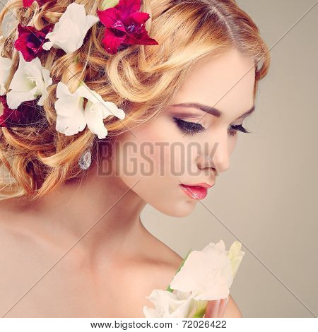 Beautiful girl, isolated on a light - grey background with varicoloured flowers in hairs, emotions, cosmetics