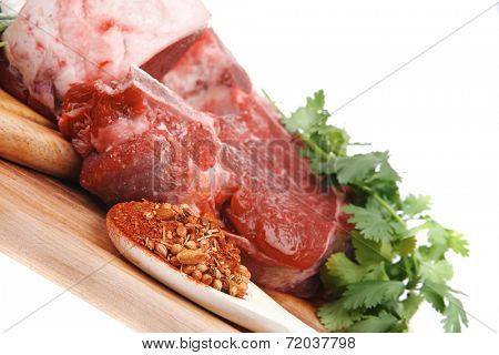 raw meat : fresh beef pork big rib and fillet with garlic and green stuff on wood isolated over white background
