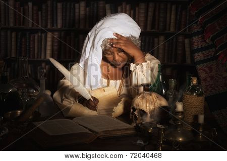 Dark image of a vintage alchemist writing in her books