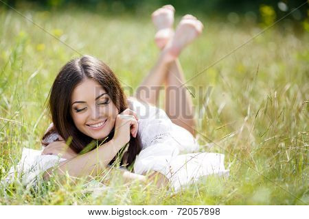 Girl resting on the soft pillow in fresh spring grass.