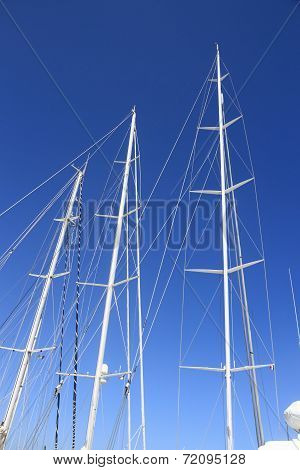 Three White Yacht Masts On Blue Sky