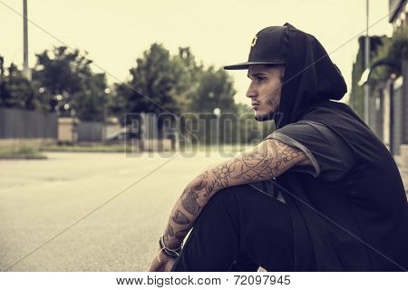 Attractive Young Man In City Sitting On Pavement