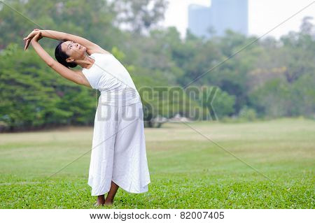 Beautiful Woman Practicing Yoga In The Park