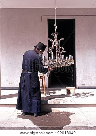 Monk cleaning light, Cyprus.