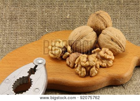 Walnuts On A Wooden Board (cutting Board) With A Nutcracker
