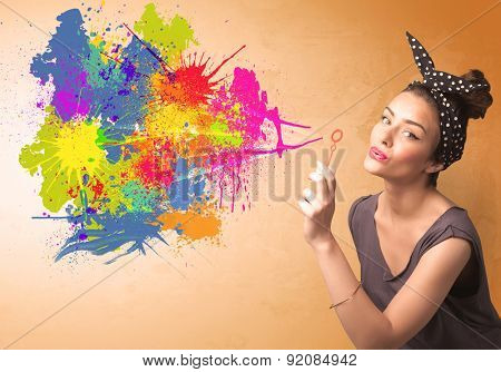Cute girl blowing bubble spalsh graffiti into wall