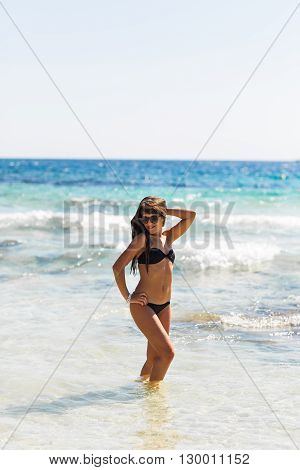 Young pretty hot sexy woman on the tropic island in summer near the sea and blue sky having fun. Young caucasian woman near ocean beach