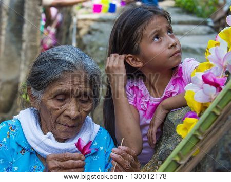 PANCHIMALCO EL SALVADOR - MAY 08 : A Salvadoran woman decorates palm fronds with flowers during the Flower & Palm Festival in Panchimalco El Salvador on May 08 2016