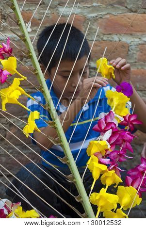 PANCHIMALCO EL SALVADOR - MAY 08 : A Salvadoran boy decorates palm fronds with flowers during the Flower & Palm Festival in Panchimalco El Salvador on May 08 2016
