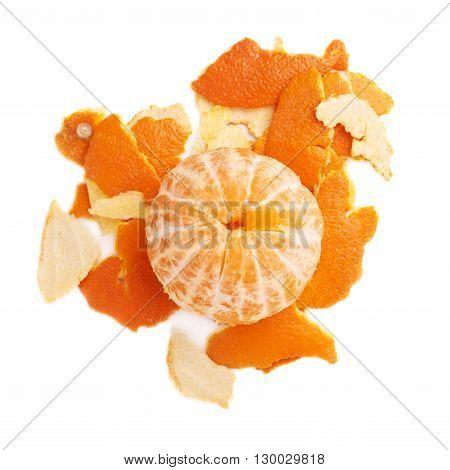 Unpealed cleaned fresh tangerine on a pile of it's peel isolated on white background, top view