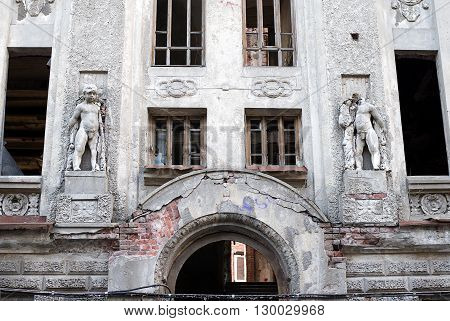 The facade of the old building with the destroyed sculptures Amurs
