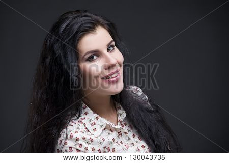 Beautiful young womanportrait. Professional makeup and hairstyle close up on a gray background