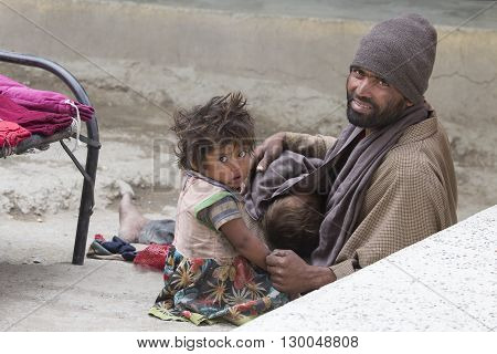 LEH INDIA - JUNE 29 2015: Unidentified poor Indian beggar family on street in Ladakh. Children of the early ages are often brought to the begging profession.