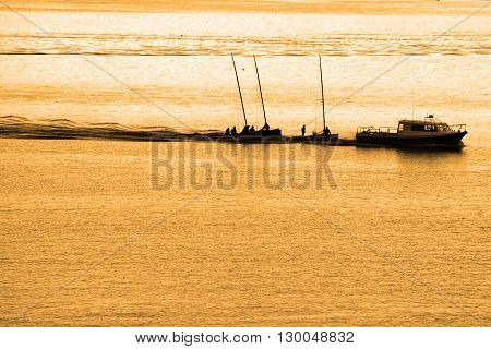 boats being towed in cobh ireland at sunset
