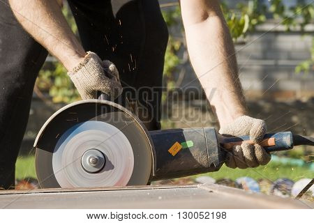 Closeup of worker hands with angle grinder