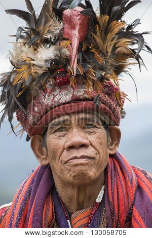 BANAUE PHILIPPINES - JANUARY 24 2014 : Unknown old ifugao man in national dress next to rice terraces. Ifugao - the people in the Philippines. Refers to the mountain peoples.