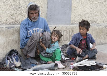 LEH INDIA - SEPTEMBER 08 2014: An unidentified beggar family begs for money from a passerby in Leh. Poverty is a major issue in India