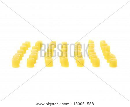 Single pieces of dry ditalini yellow pasta over isolated white background