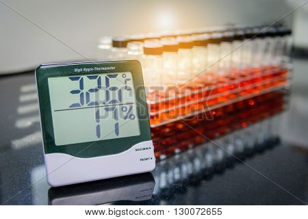 Digital hygro thermometer with blurred test tube in laboratory