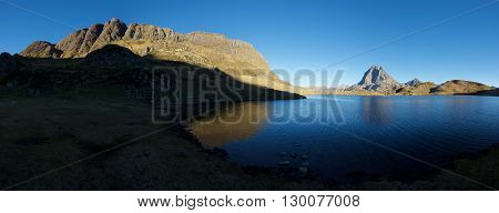 Midi Dossau Peak reflected in Gentau lake. Ossau Valley, Pyrenees National Park, Pyrenees, France.