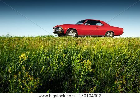 Saratov, Russia - June 07, 2015: Retro red car Chevrolet Malibu stay on asphalt road at sunset