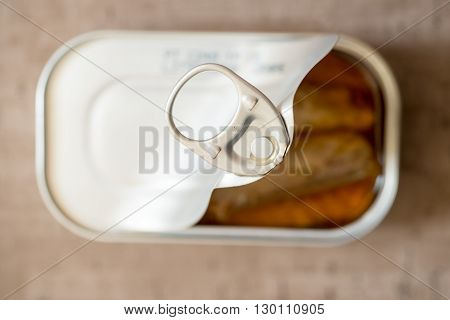 Ring pull of a half-opened can of sardines or herring in oil