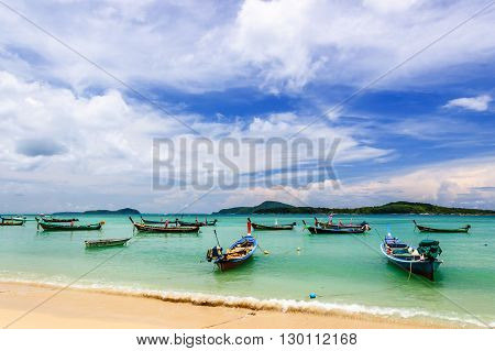 Rawai Thailand - August 25 2014: Long-tail boats for fishing & tourist trips moored in bay at Rawai beach on southern tip of Phuket southern Thailand