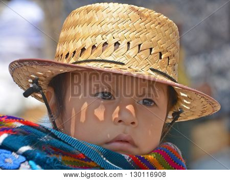 CHICHICASTENANGO GUSTEMALA APRIL 29 2016: Portrait of a Mayan baby carried on the back of his mother. The Mayan people still make up a majority of the population in Guatemala,