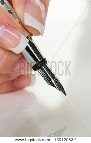 hand with fountain pen signing contract